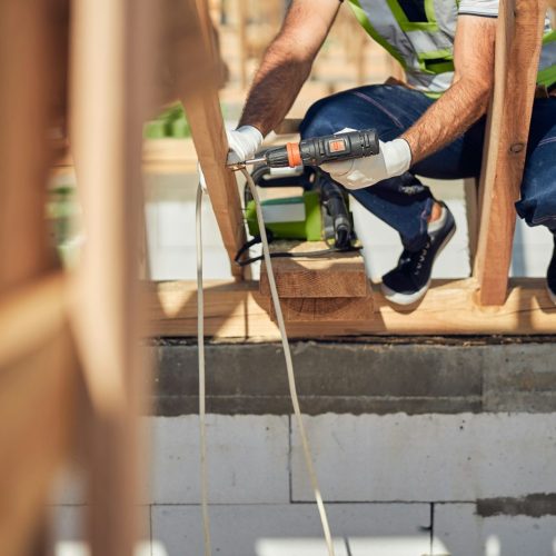 Close up of professional constructor using screwdriver