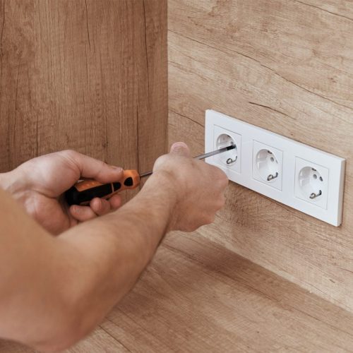 Electrician installing socket in the kitchen
