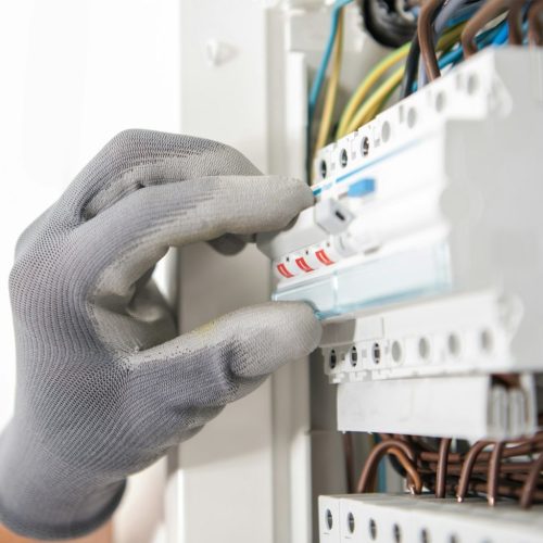 Electrician Testing Fuses In the Electric Box