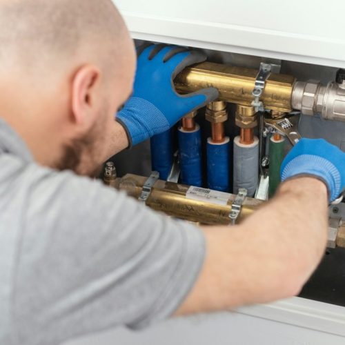 Professional plumber installing plumbing manifolds